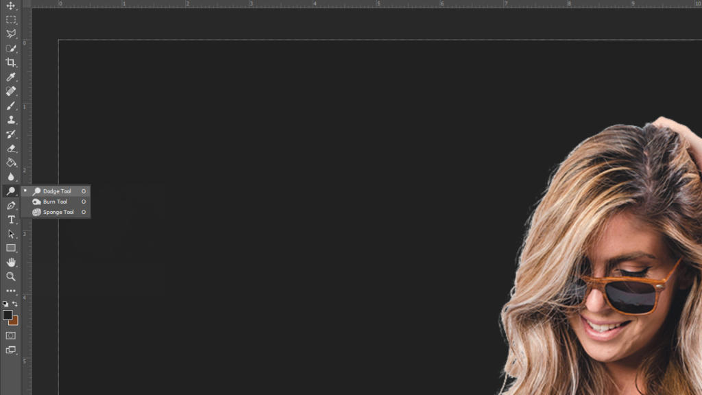 Una donna che indossa occhiali da sole e sorride è posizionata sul lato destro di un'area di lavoro di Photoshop. Lo sfondo nero contrasta con vari strumenti di modifica sulla sinistra, perfetti per attività come scontornare i capelli in Photoshop.