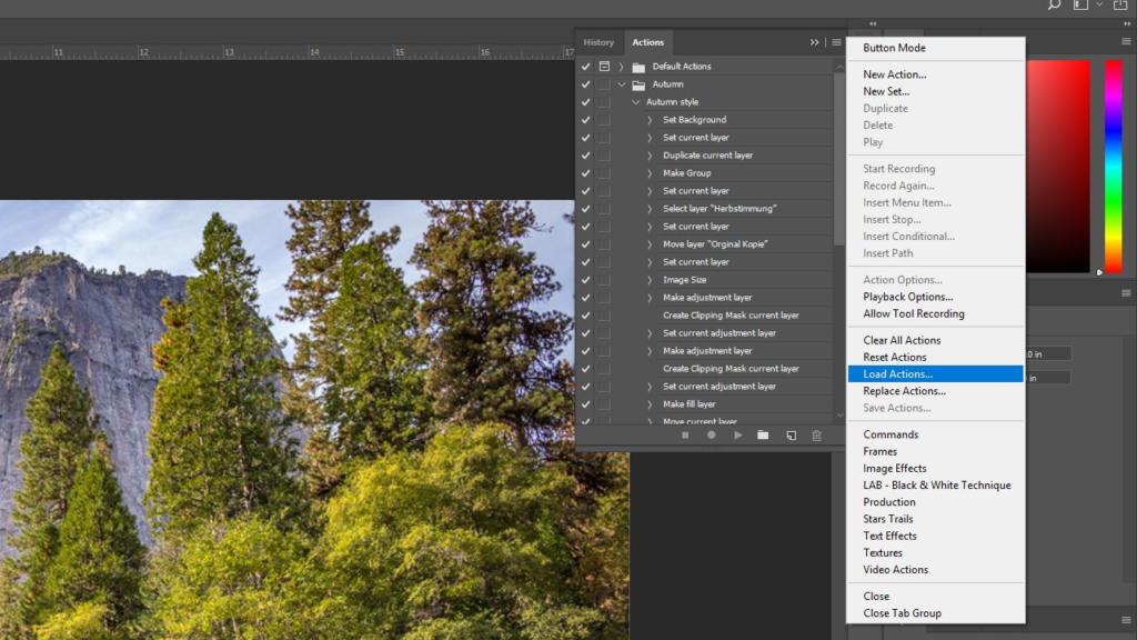 Uno schermo di computer mostra un software di editing con un'immagine di paesaggio di alberi e una montagna. L'interfaccia di Photoshop mostra un elenco di azioni sulla destra, con un'opzione evidenziata in un menu.
