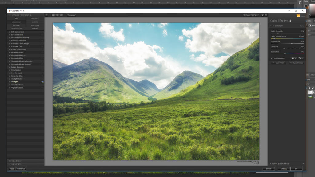 Screenshot di un'interfaccia software di fotoritocco migliorata da Google Nik Collection, che mostra un'immagine di paesaggio. L'immagine mostra una lussureggiante valle verde con dolci colline sotto un cielo parzialmente nuvoloso. Gli strumenti di modifica sono visibili sul lato destro dell'interfaccia.