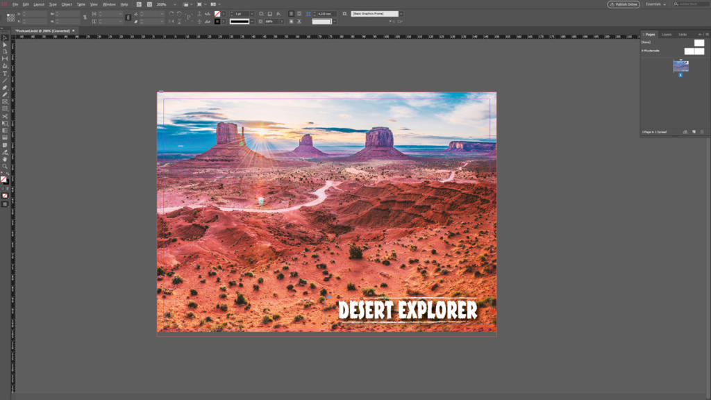 Screenshot di un'area di lavoro di Adobe InDesign con un design di cartolina con un paesaggio desertico. La scena mostra delle colline sotto un cielo all'alba. Il testo sulla cartolina recita DESERT EXPLORER, con i dati per la stampa visibili. L'interfaccia mostra vari strumenti di modifica e pannelli.