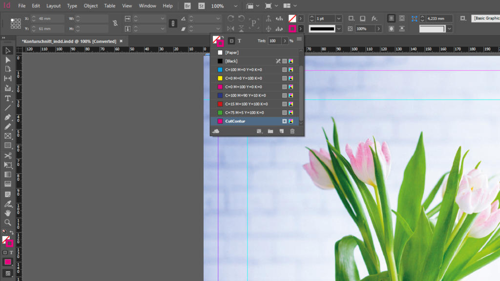 Screenshot di un'area di lavoro InDesign che mostra un'immagine floreale parzialmente visibile sulla destra con un taglio del contorno preciso e barre degli strumenti piene di campioni di colore e strumenti di progettazione sulla sinistra. Il menu in alto include opzioni come File, Modifica e Visualizza.