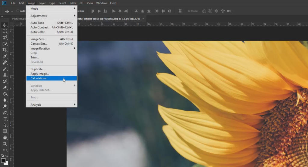 Un'interfaccia software di editing digitale mostra un'immagine di un petalo di girasole giallo brillante sulla destra. Un menu a discesa è aperto sul lato sinistro, elencando varie opzioni di regolazione, tra cui la funzione "bianco e nero in Photoshop" per straordinarie trasformazioni in bianco e nero.