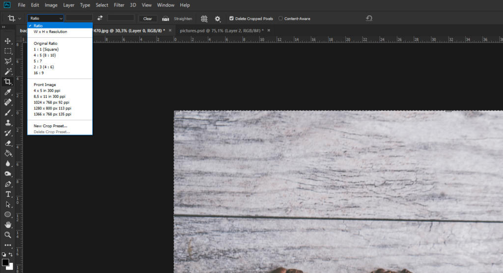 Screenshot di un'interfaccia software di editing delle immagini, che ricorda quando si ritaglia immagine in Photoshop, che mostra un menu con opzioni di rapporto di ritaglio. Lo sfondo mostra elegantemente parte di una texture di superficie in legno.