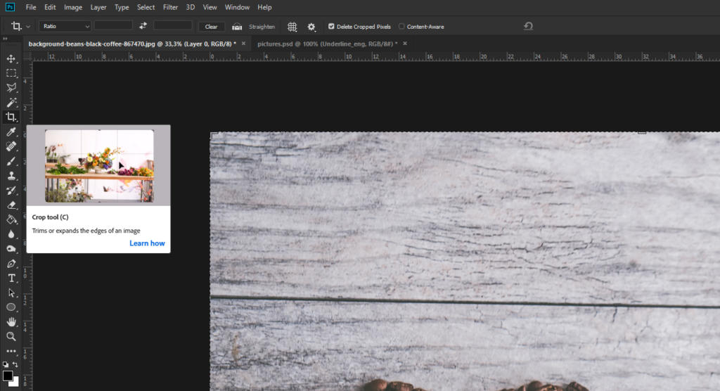 Uno schermo di computer che mostra Photoshop mostra un'immagine di una superficie di legno rustico con noci. L'interfaccia presenta strumenti e opzioni di ritagliare immagine, completati da una piccola anteprima nell'angolo in alto a sinistra.