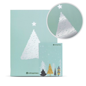 Un biglietto di auguri verde menta con un albero di Natale in lamina argentata e un design a forma di stella. Include biglietti più piccoli con alberi colorati sotto un cielo stellato. Il primo piano mostra i dettagli riflettenti delle lamine.
